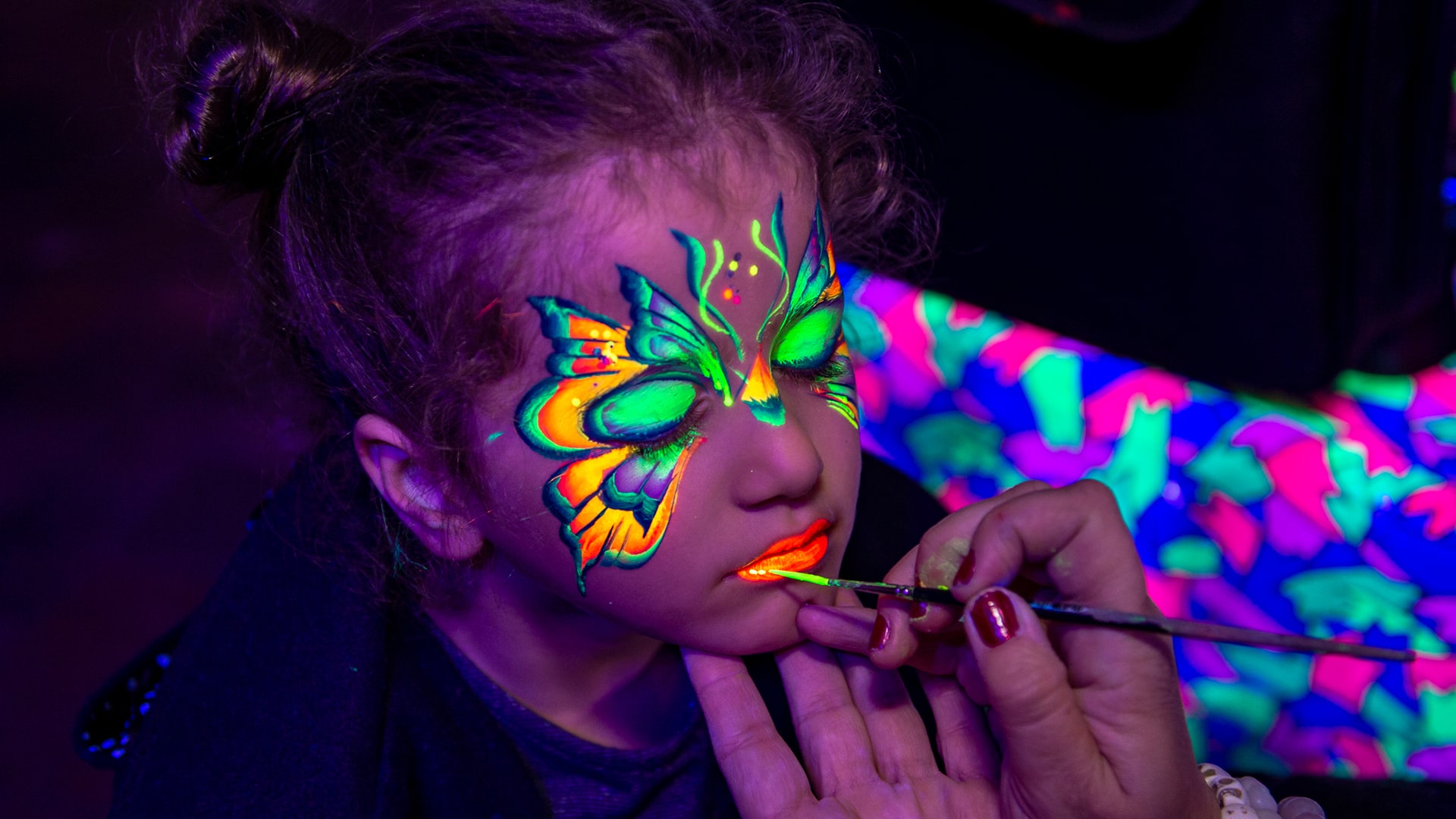 A child getting their face painted with glow in the dark paint in the rocks, Sydney
